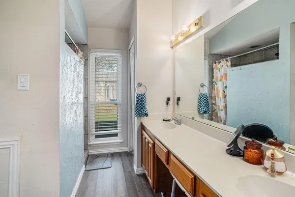 a bathroom with a sink a large mirror and a shower