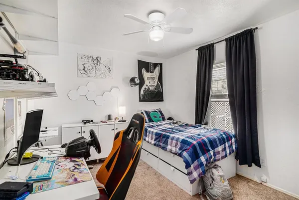 a bedroom with furniture a flat screen tv and a window
