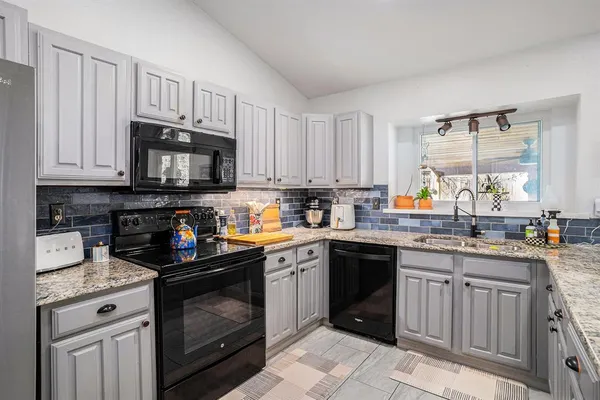 a kitchen with stainless steel appliances granite countertop a stove sink microwave and cabinets