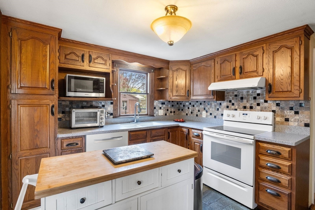 42 Wapping Road Kingston, MA 02364 - Photo 14 of 25 a kitchen with granite countertop stainless steel appliances a stove microwave and cabinets