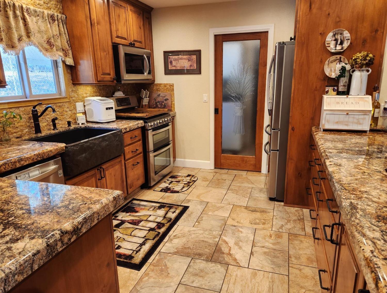 28903 Limestone Circle Coarsegold, CA 93614 - Photo 13 of 59 a kitchen with stainless steel appliances granite countertop a refrigerator and a stove
