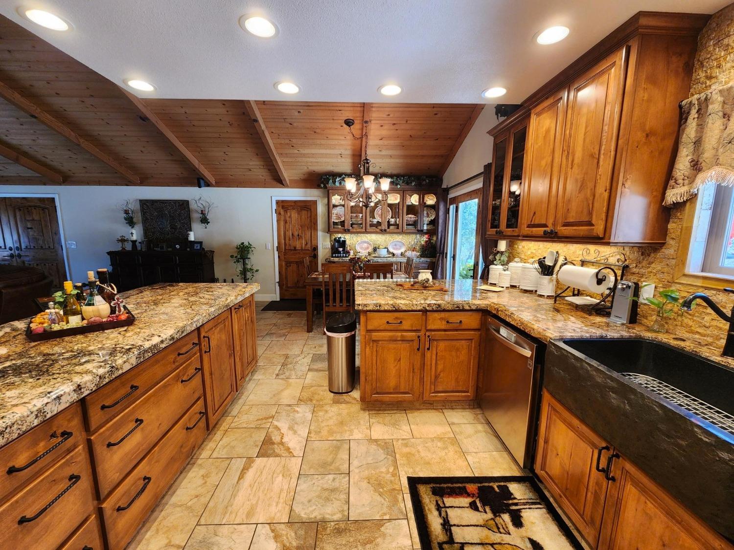 28903 Limestone Circle Coarsegold, CA 93614 - Photo 15 of 59 a kitchen with stainless steel appliances kitchen island granite countertop a sink and cabinets
