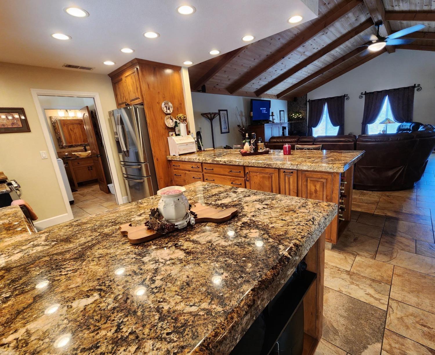 28903 Limestone Circle Coarsegold, CA 93614 - Photo 17 of 59 a living room with kitchen island granite countertop furniture and a flat screen tv