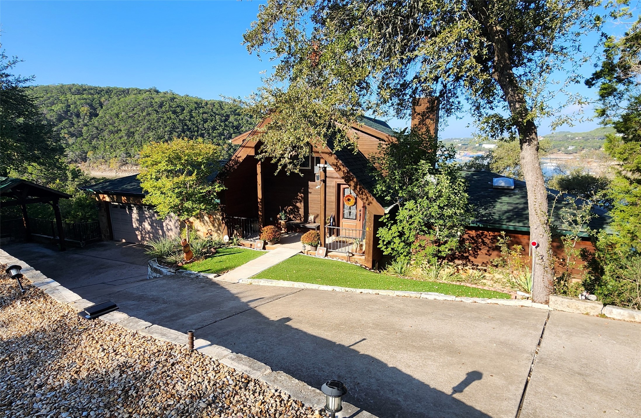 View of front of home with a garage, a chimney, concrete driveway, a shingled roof, and a front lawn