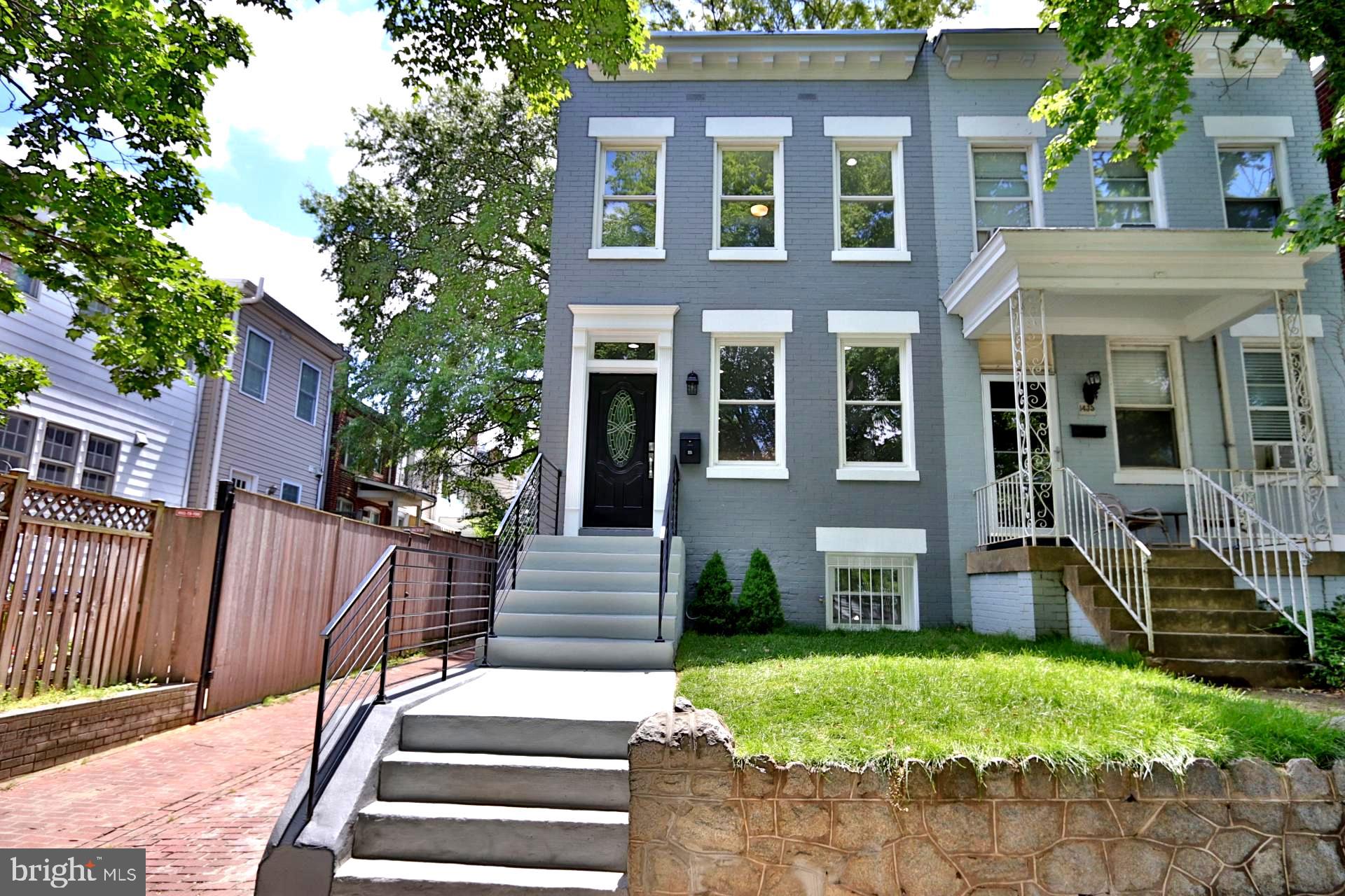 a view of a brick house with a yard and plants