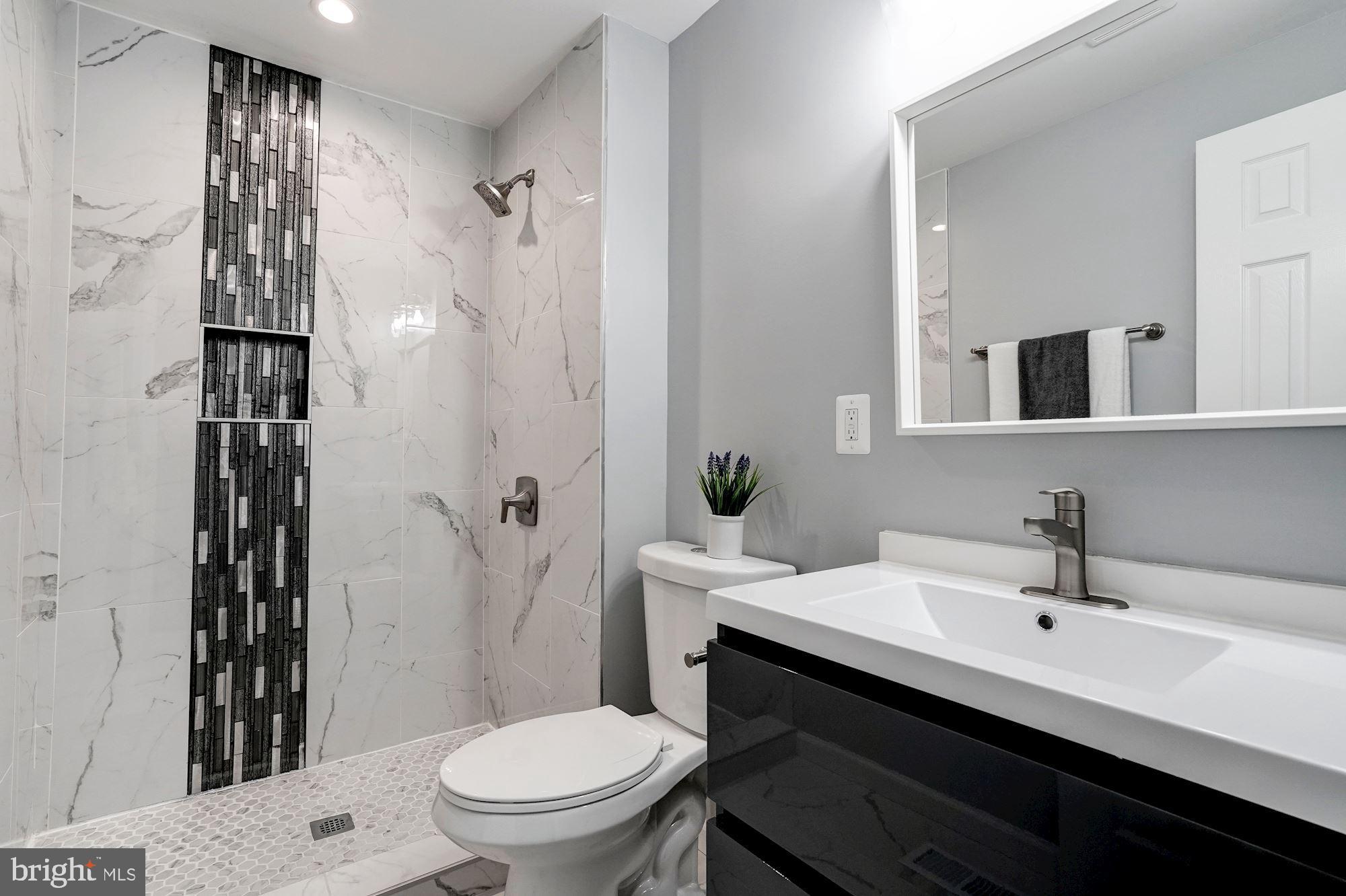 1437 E Street Northeast Washington, DC 20002 - Photo 26 of 39 a bathroom with a sink a toilet a shower and a mirror