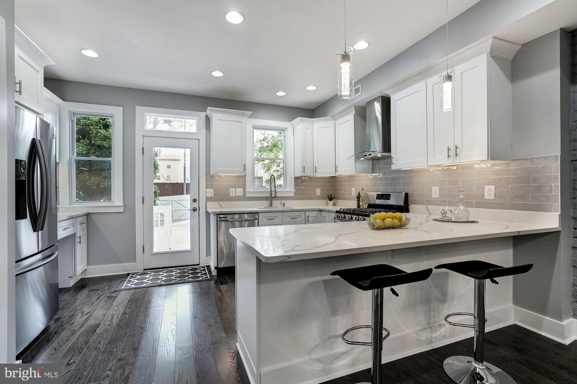 1437 E Street Northeast Washington, DC 20002 - Photo 10 of 39 a kitchen with stainless steel appliances granite countertop counter top space a refrigerator and cabinets