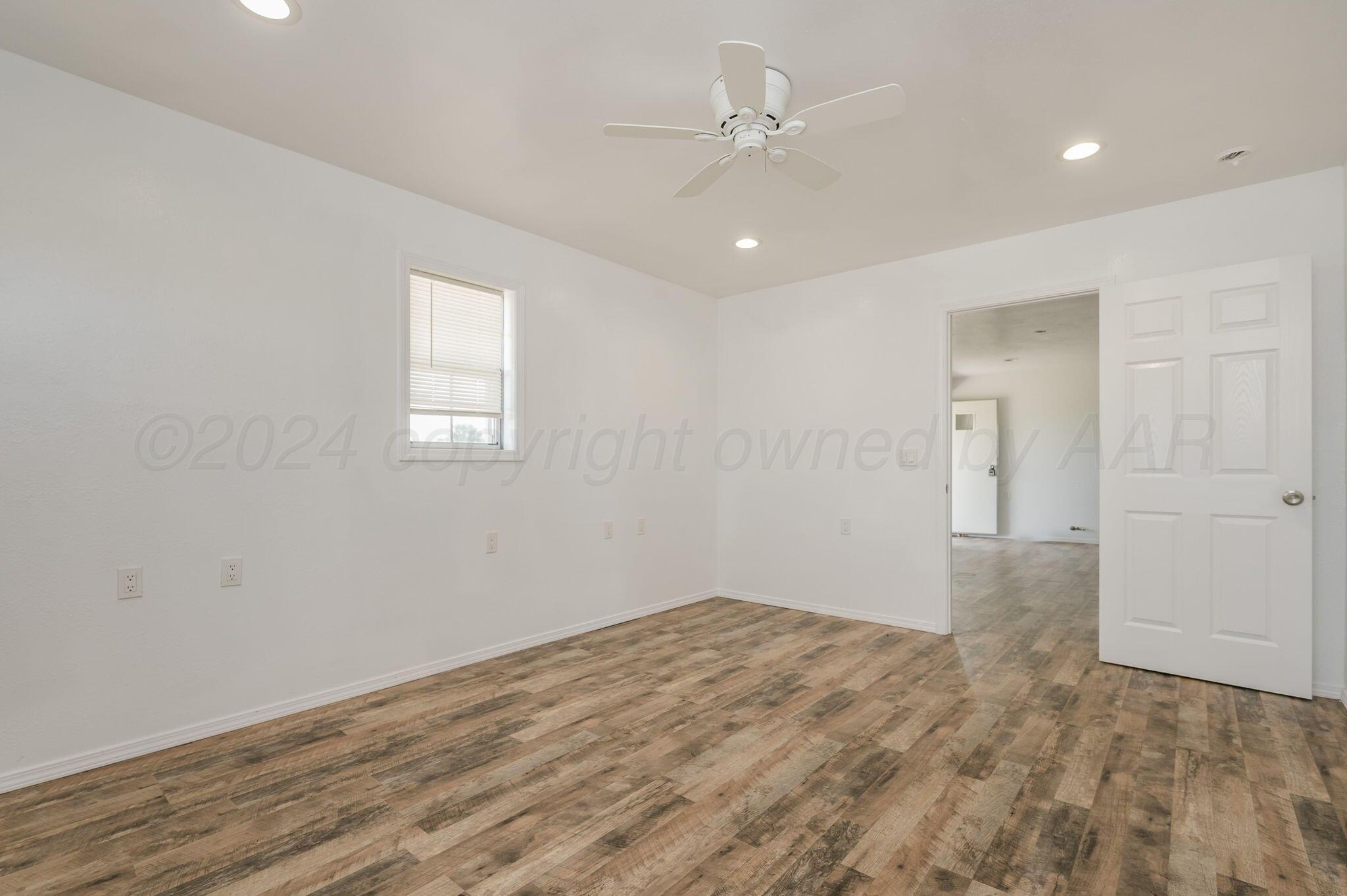 621 Plainview Street Howardwick, TX 79226 - Photo 11 of 18 wooden floor in an empty room with a window
