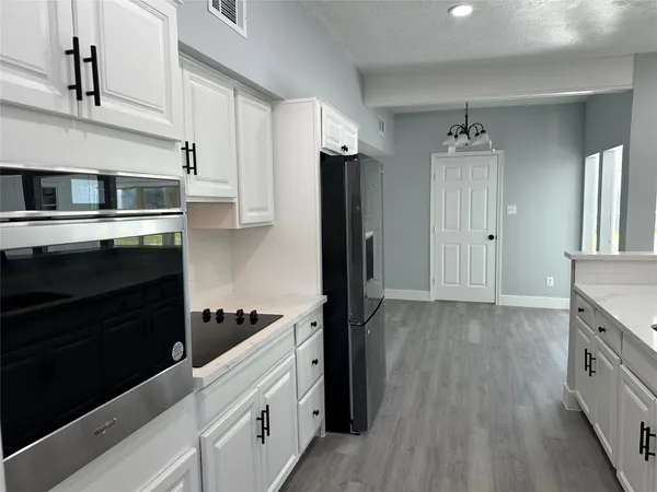 a kitchen with stainless steel appliances a refrigerator stove and cabinets
