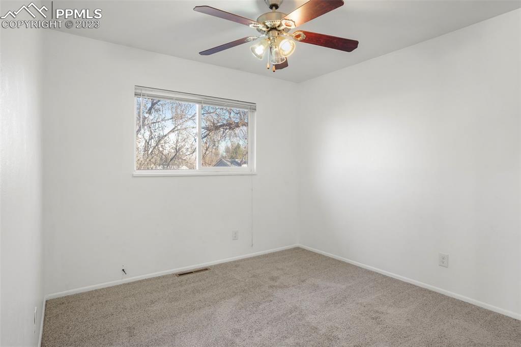 1159 Peterson Road Colorado Springs, CO 80915 - Photo 14 of 22 an empty room with a window and a fan