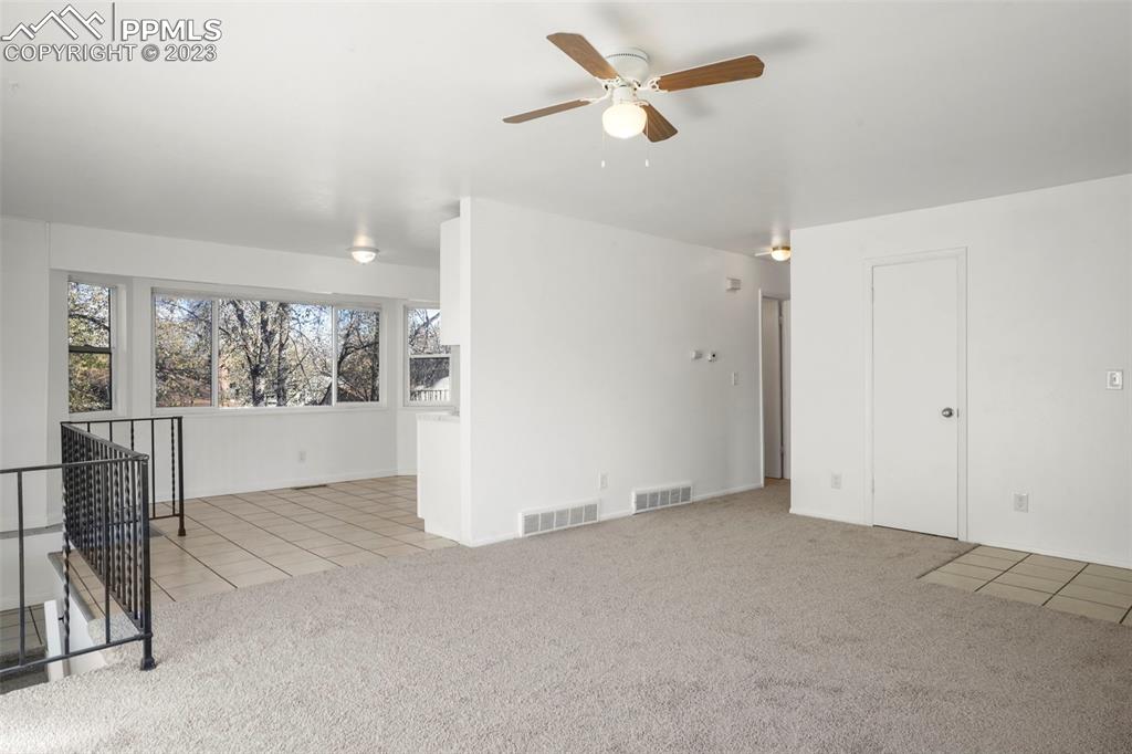 1159 Peterson Road Colorado Springs, CO 80915 - Photo 4 of 22 an empty room with windows and fan