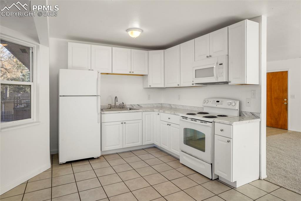 1159 Peterson Road Colorado Springs, CO 80915 - Photo 7 of 22 a view of kitchen with white cabinets