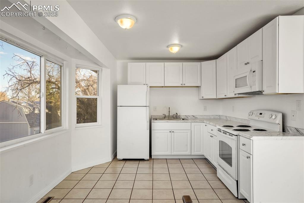 1159 Peterson Road Colorado Springs, CO 80915 - Photo 8 of 22 a kitchen with a stove a sink and a refrigerator