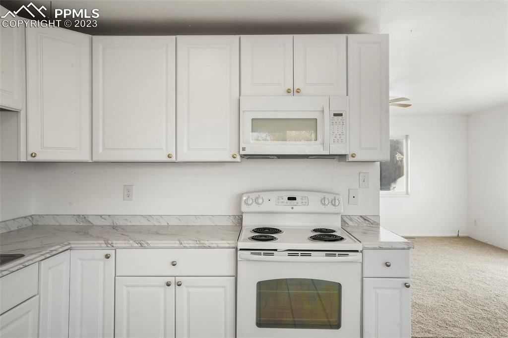 1159 Peterson Road Colorado Springs, CO 80915 - Photo 9 of 22 a stove top oven sitting inside of a kitchen