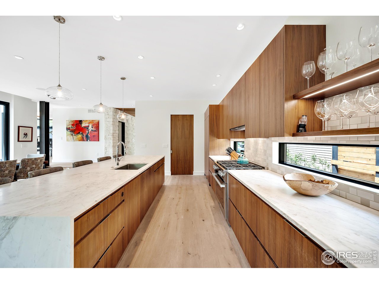 550 Iris Avenue Boulder, CO 80304 - Photo 7 of 40 a large kitchen with stainless steel appliances kitchen island granite countertop a large counter top a stove a sink a refrigerator and white cabinets with wooden floor