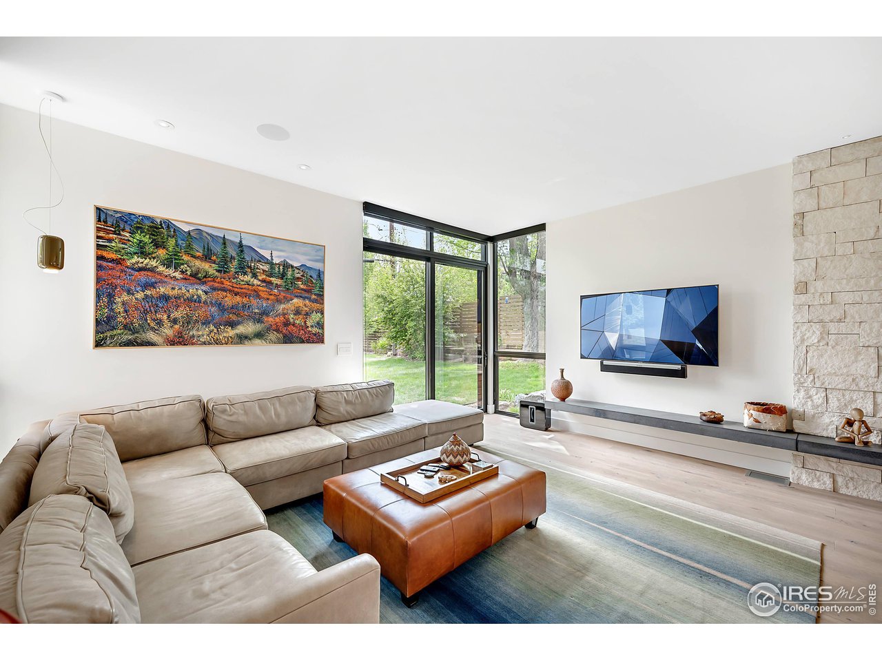 550 Iris Avenue Boulder, CO 80304 - Photo 9 of 40 a living room with furniture a flat screen tv and a floor to ceiling window