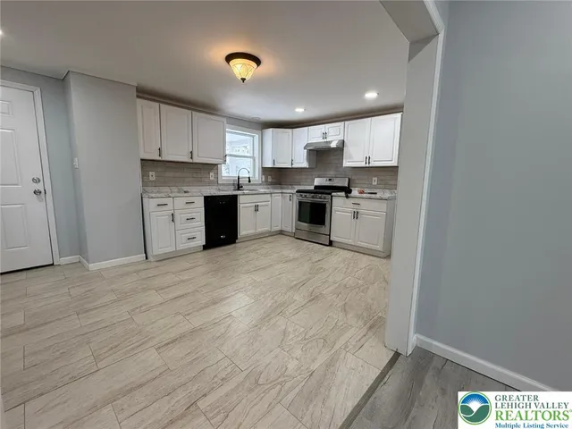 a kitchen with stainless steel appliances granite countertop a stove a sink and a refrigerator