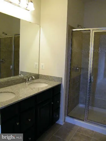 a bathroom with a double vanity sink and a mirror