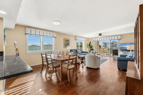 a kitchen with granite countertop a refrigerator and white cabinets