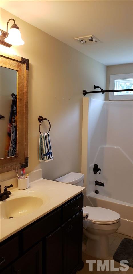 2021 Sageleaf Court Raleigh, NC 27603 - Photo 14 of 20 a bathroom with a sink a toilet and shower