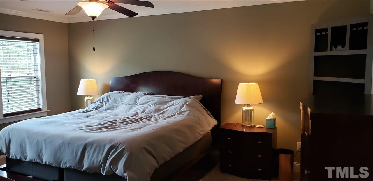 2021 Sageleaf Court Raleigh, NC 27603 - Photo 7 of 20 a bedroom with a bed and a chandelier