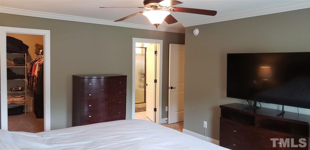 2021 Sageleaf Court Raleigh, NC 27603 - Photo 8 of 20 a bedroom with a bed and a flat screen tv