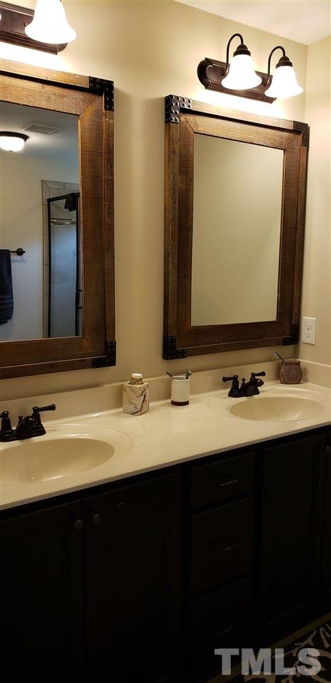 2021 Sageleaf Court Raleigh, NC 27603 - Photo 10 of 20 a bathroom with a sink and a mirror