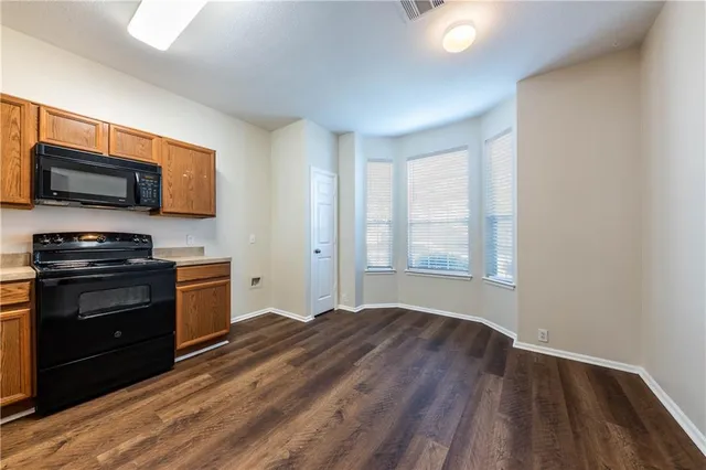 a kitchen with granite countertop wooden floors and stainless steel appliances