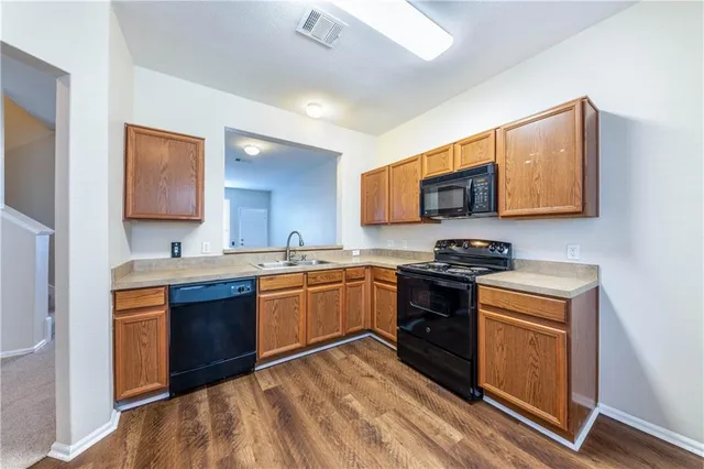 a kitchen with stainless steel appliances granite countertop wooden cabinets stove top oven and sink