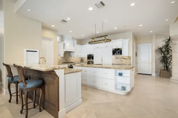 a kitchen with kitchen island cabinets and chairs in it