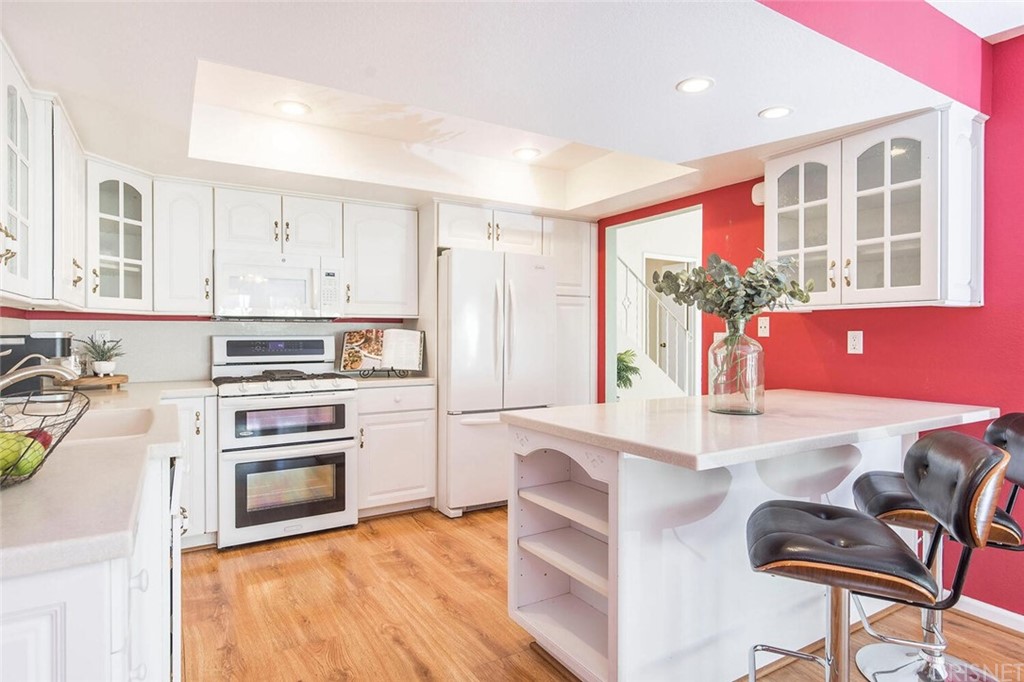27003 Rio Prado Drive Valencia, CA 91354 - Photo 12 of 27 a kitchen with stainless steel appliances granite countertop a stove and a refrigerator