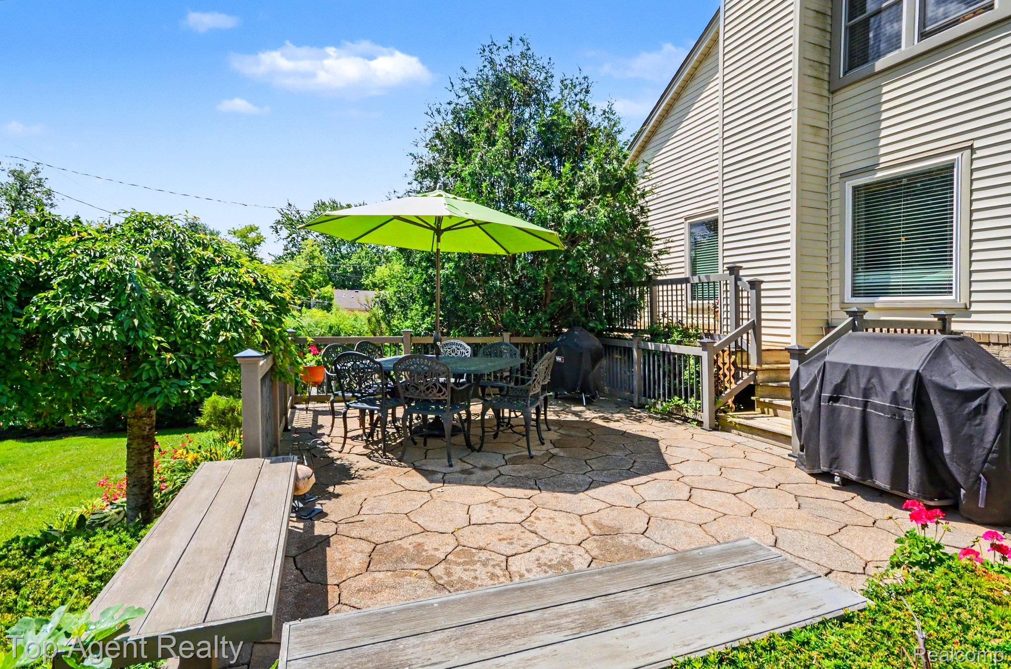 3759 Donley Avenue Rochester, MI 48309 - Photo 20 of 29 Expansive flagstone patio with a dining area, bordered by lush landscaping and a manicured lawn