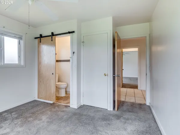 a view of empty room with a bathroom and a mirror