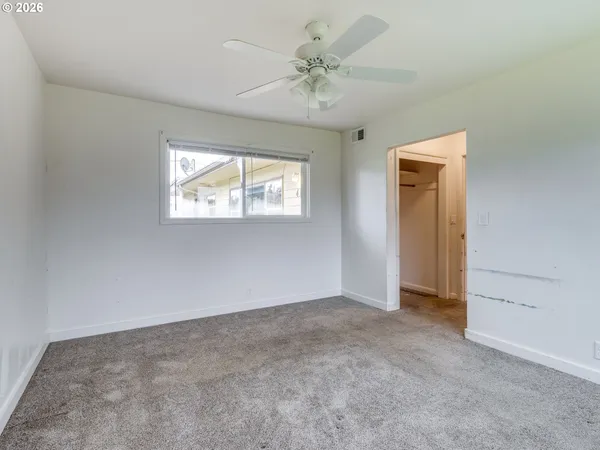 an empty room with windows and closet