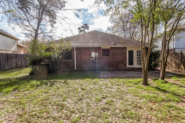 a view of a house with backyard and a tree