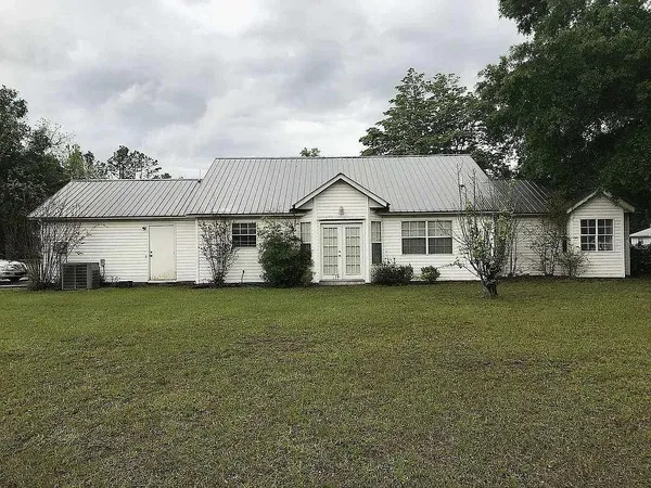a view of a yard in front of a house with a large tree