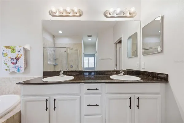 a bathroom with double sink and a mirror