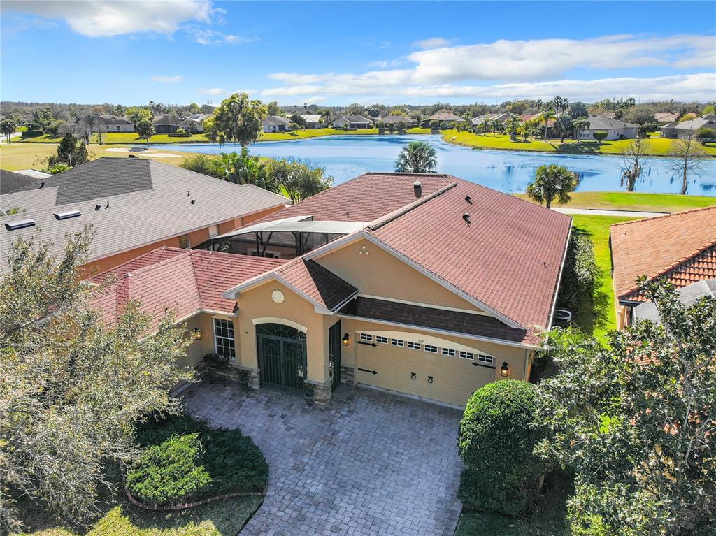 an aerial view of a house with a yard and lake view