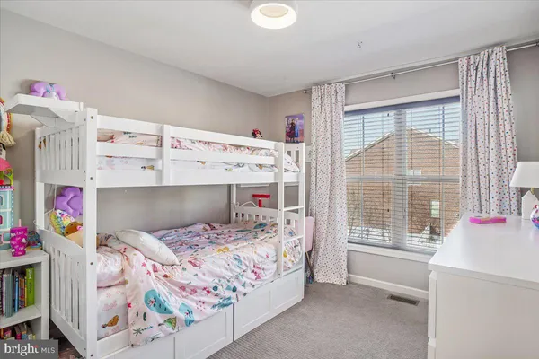 a bedroom with a bed a chair and potted plant