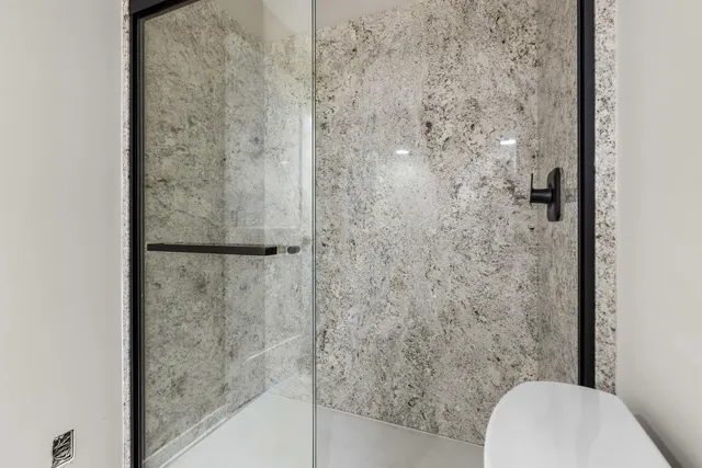 a bathroom with a toilet and a shower