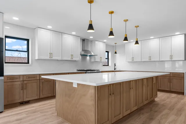 a kitchen with kitchen island a sink stainless steel appliances and cabinets