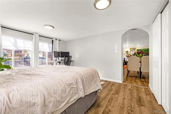 a bedroom with a bed and a large window with the outer view
