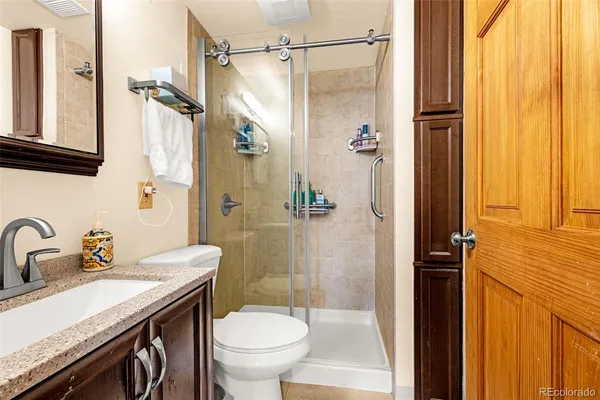 a bathroom with a granite countertop sink toilet and shower