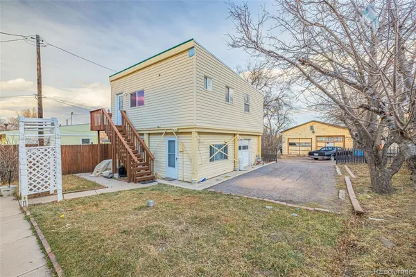 a view of a house with backyard and a tree
