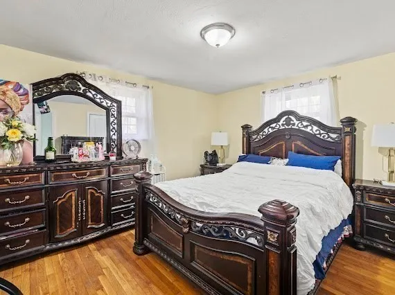 a bedroom with a bed and a mirror on the dresser