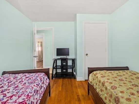 a bedroom with a bed and a flat tv screen on a dresser