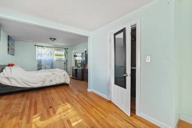 a bedroom with a bed and wooden floor
