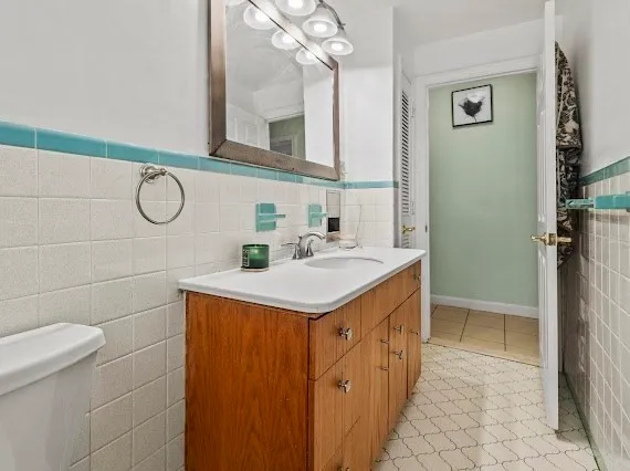 a bathroom with a sink a toilet and a mirror