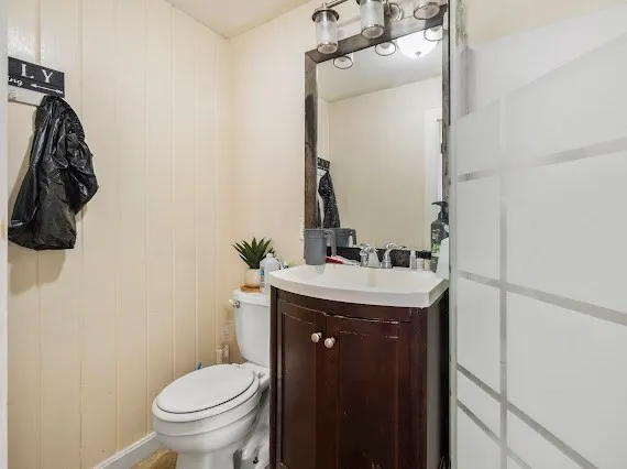a bathroom with a granite countertop sink toilet and mirror