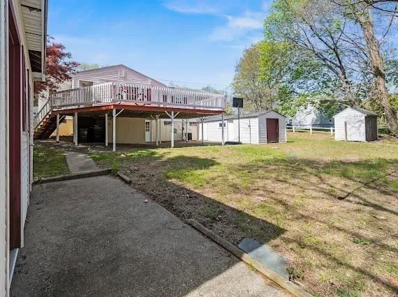 a view of a house with a yard and large tree